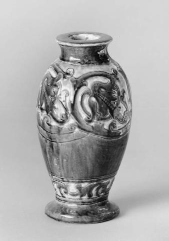 Artwork Vase: (scrolls) this artwork made of Earthenware, handbuilt baluster shape, dipped brown slip and carved.  Light green glaze, created in 1936-01-01