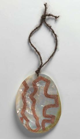 A decorated pearlshell pendant on a weaved string loop