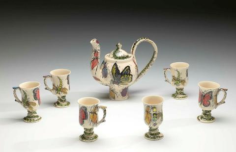 Artwork Teapot and cups:  Happy wanderer this artwork made of Earthenware, cream clay wheelthrown and slip-cast with polychrome decorations beneath clear glaze, created in 1995-01-01