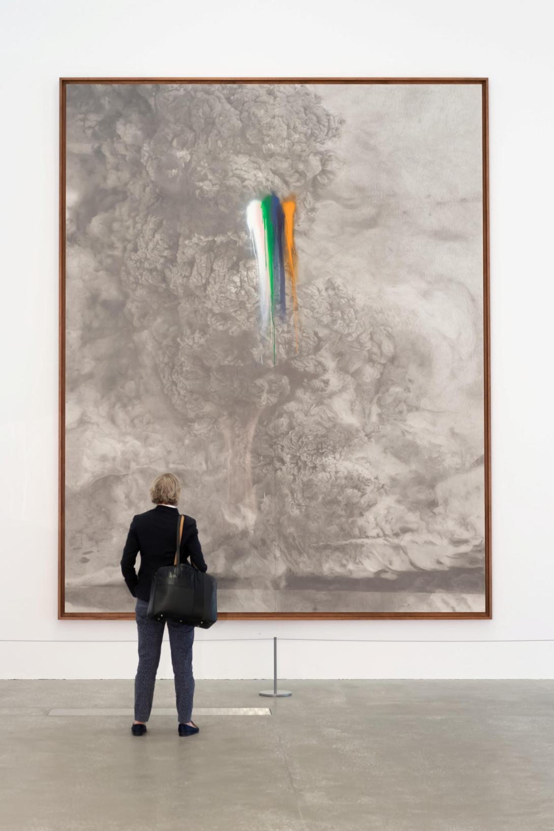 An installation view of a painting of a great grey cloud, with the colours of agent orange and similar chemicals splashed through the work's centre.